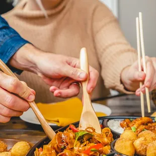 a woman eating a meal with chopsticks