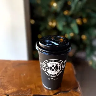 a cup of coffee on a wooden table