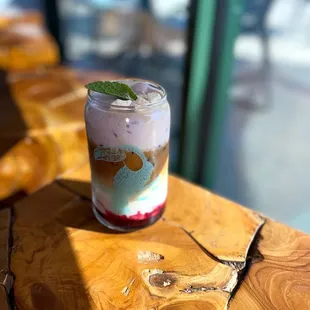 a glass of ice cream with a mint leaf on top