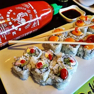 a plate of sushi and chopsticks