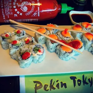 a plate of sushi and chopsticks