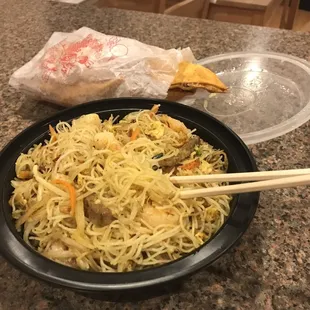 a bowl of noodles and chopsticks