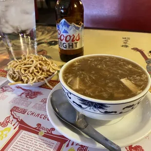 a bowl of soup and a bottle of beer