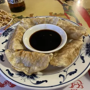 a plate of dumplings with dipping sauce