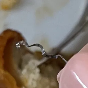 a person holding a fork with a piece of food on it