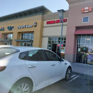 a white car parked in front of a restaurant