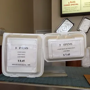 two trays of food sitting on a counter