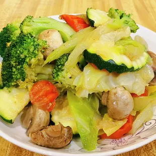 a plate of chinese food on a wooden table
