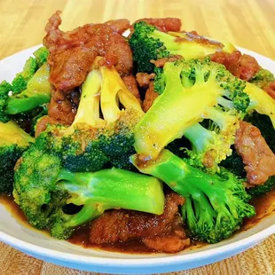 a bowl of chinese food with meat and broccoli