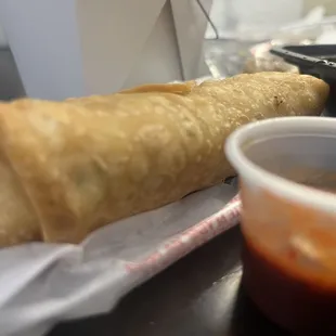 a pastry and dipping sauce on a table