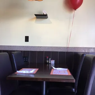 a table and chairs with a balloon on the wall