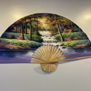 a painting of a waterfall and a fan