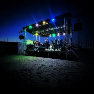 HomeSlice performing on the sand.