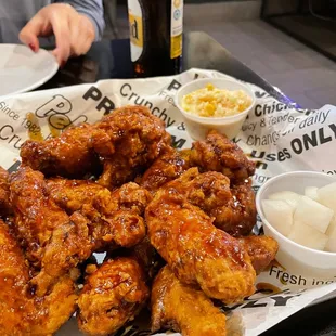 a plate of chicken wings with a side of macaroni and cheese