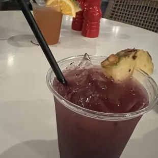 In the front is the Black Pearl (Malibu Rum, Cruzan rum, blackberry purée, pineapple juice), and a Mai Tai in the background.