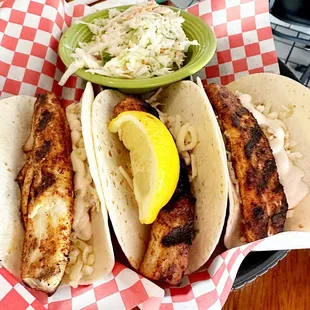 three fish tacos and a side of coleslaw