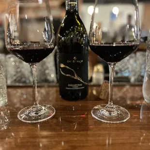 three glasses of wine and a bottle of wine