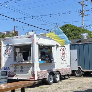 a food truck parked next to a picnic table