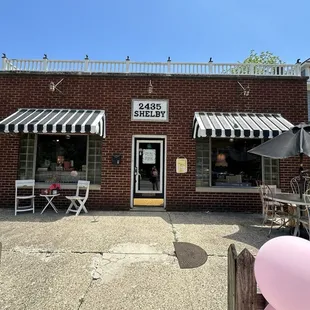 Front of business, little cat hanging out in the window