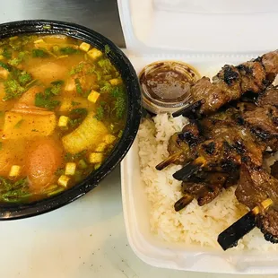 a bowl of soup and a plate of meat skewers