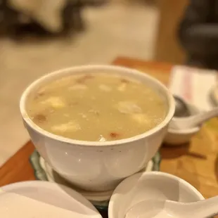 a bowl of soup and spoons on a table