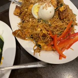 a plate of noodles with a boiled egg on top