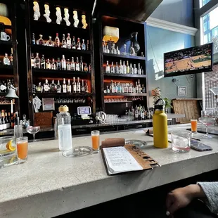 a woman sitting at a bar with drinks