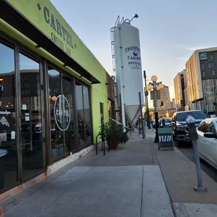 a woman walking down a sidewalk in front of a coffee shop