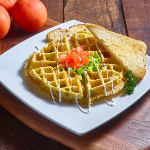 a plate of waffles and tomatoes