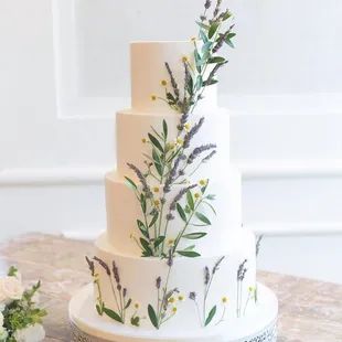 a three tiered wedding cake decorated with wildflowers