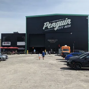 The large parking lot, huge building, and cider joint next door