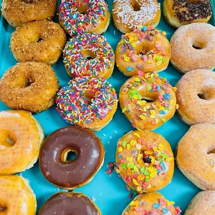 a variety of doughnuts on a tray