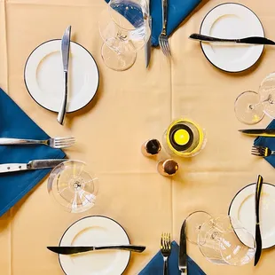 a table setting with blue napkins and silverware