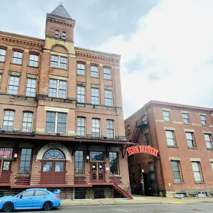 a blue car parked in front of a brick building