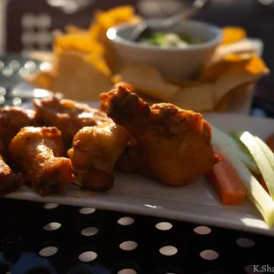 a platter of chicken wings and vegetables