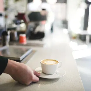 a person holding a cup of coffee