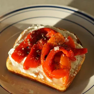 a toasted sandwich with cream cheese and red peppers