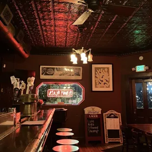 a bar with stools and a clock on the wall
