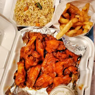 The whole spread featuring hot wings, French fries, and a side of veggie fried rice