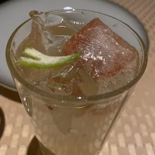 a glass of water with ice and a lime slice