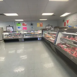 a man standing in front of a display of meat