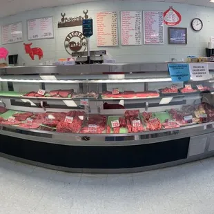 a man standing in front of a display of meat