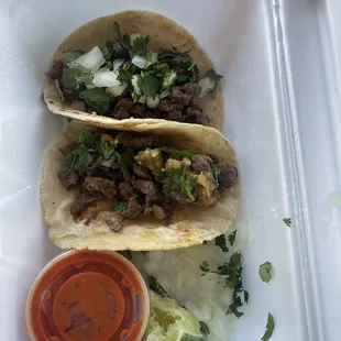 two tacos in a styrofoam container
