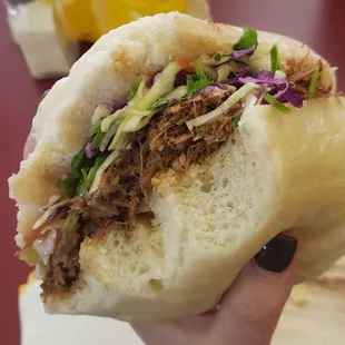 a person holding a sandwich