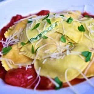 Spinach and Cheese Ravioli topped with tomato sauce, fresh basil and parmesan cheese.