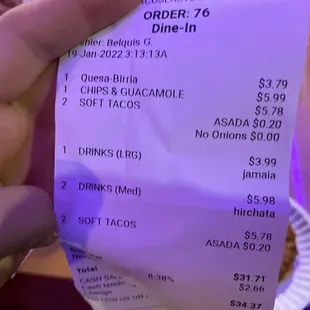 a hand holding a receipt