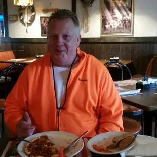 a man sitting at a table eating pizza