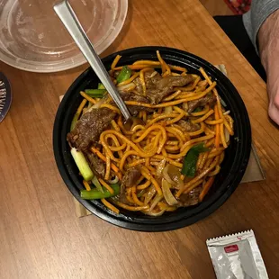 a bowl of noodles with meat and vegetables