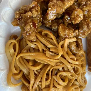 Spicy sesame chicken with lo mein and an egg roll.