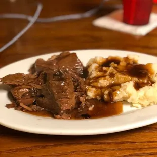 a plate of beef and mashed potatoes